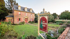 Un edificio de ladrillo con un letrero que indica The Cedars B&B.
