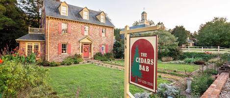 Um edifício de tijolos com uma placa indicando o Cedars B&B.