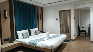 A modern hotel room with a large bed, a bedside table, a desk, and a chair. - Hotel Supreme (Vasco) (Vasco da Gama)