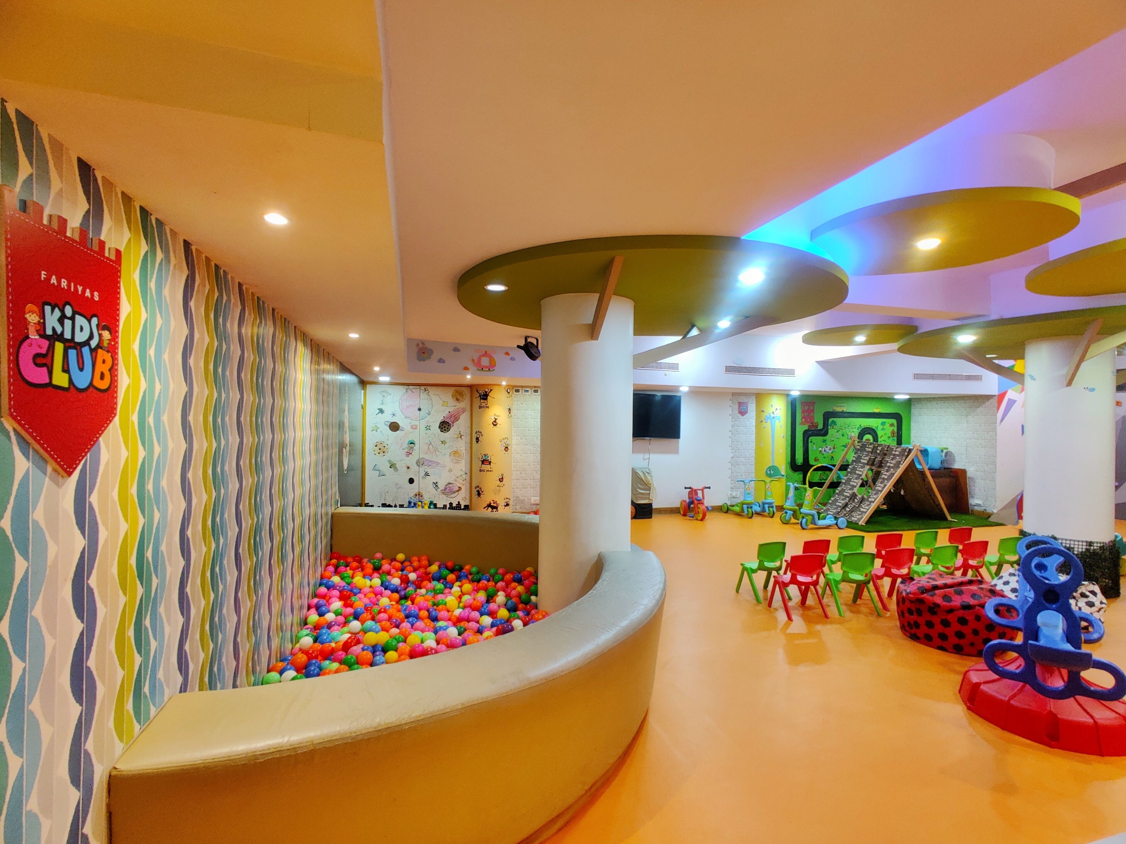 A children's play area with colorful walls, a ball pit, and various play structures.