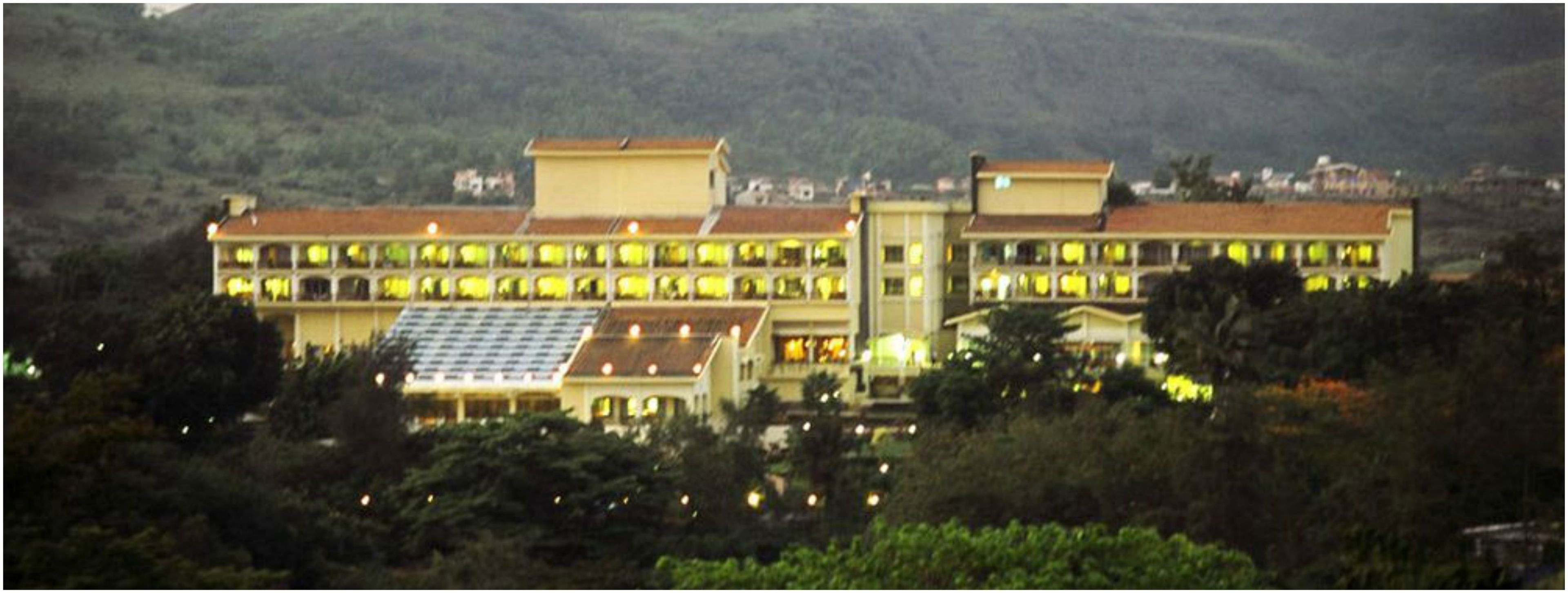 A large hotel with multiple floors, a flat roof, and a prominent solar panel array.