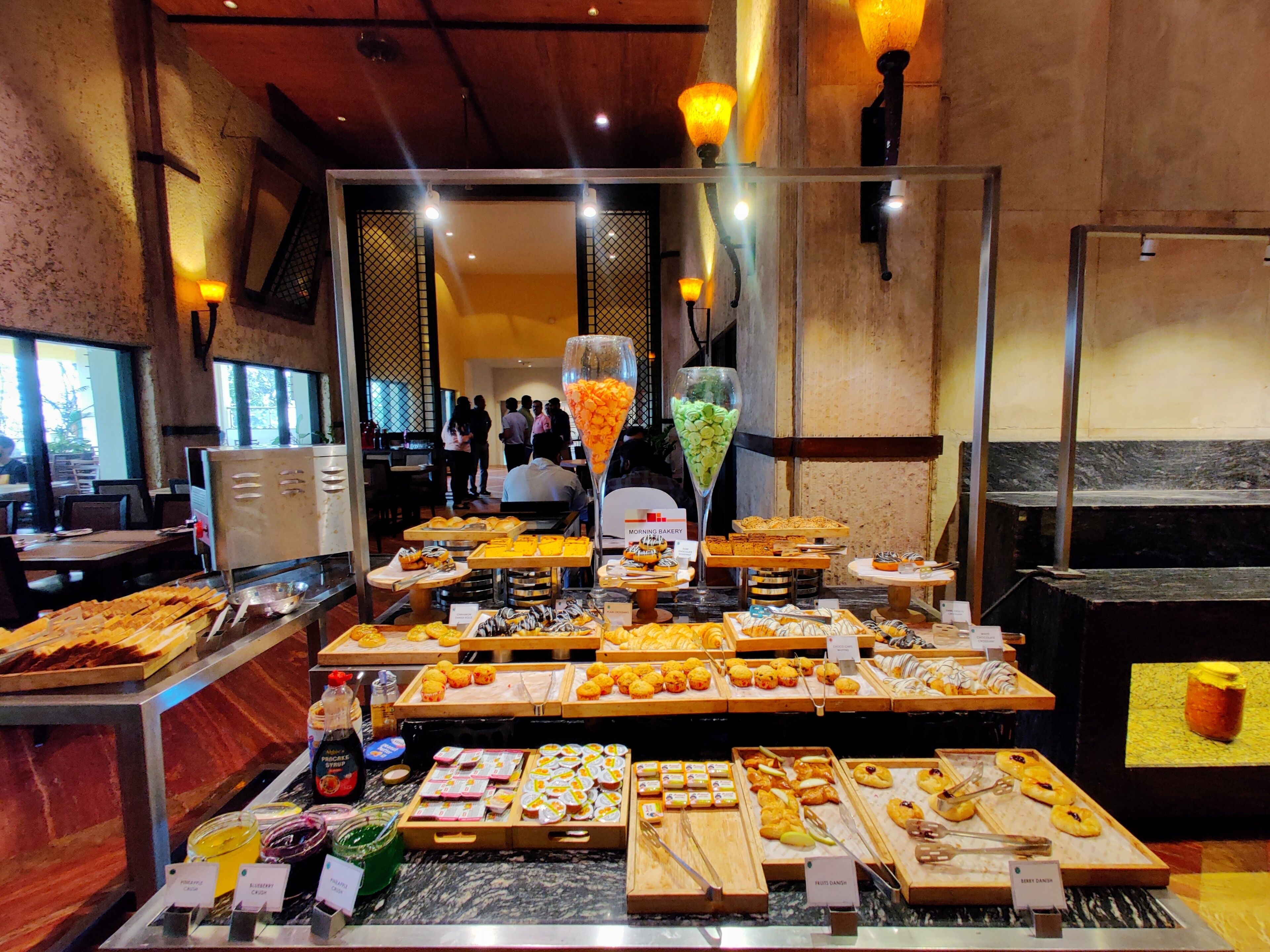 A breakfast buffet with various pastries, fruits, and condiments.