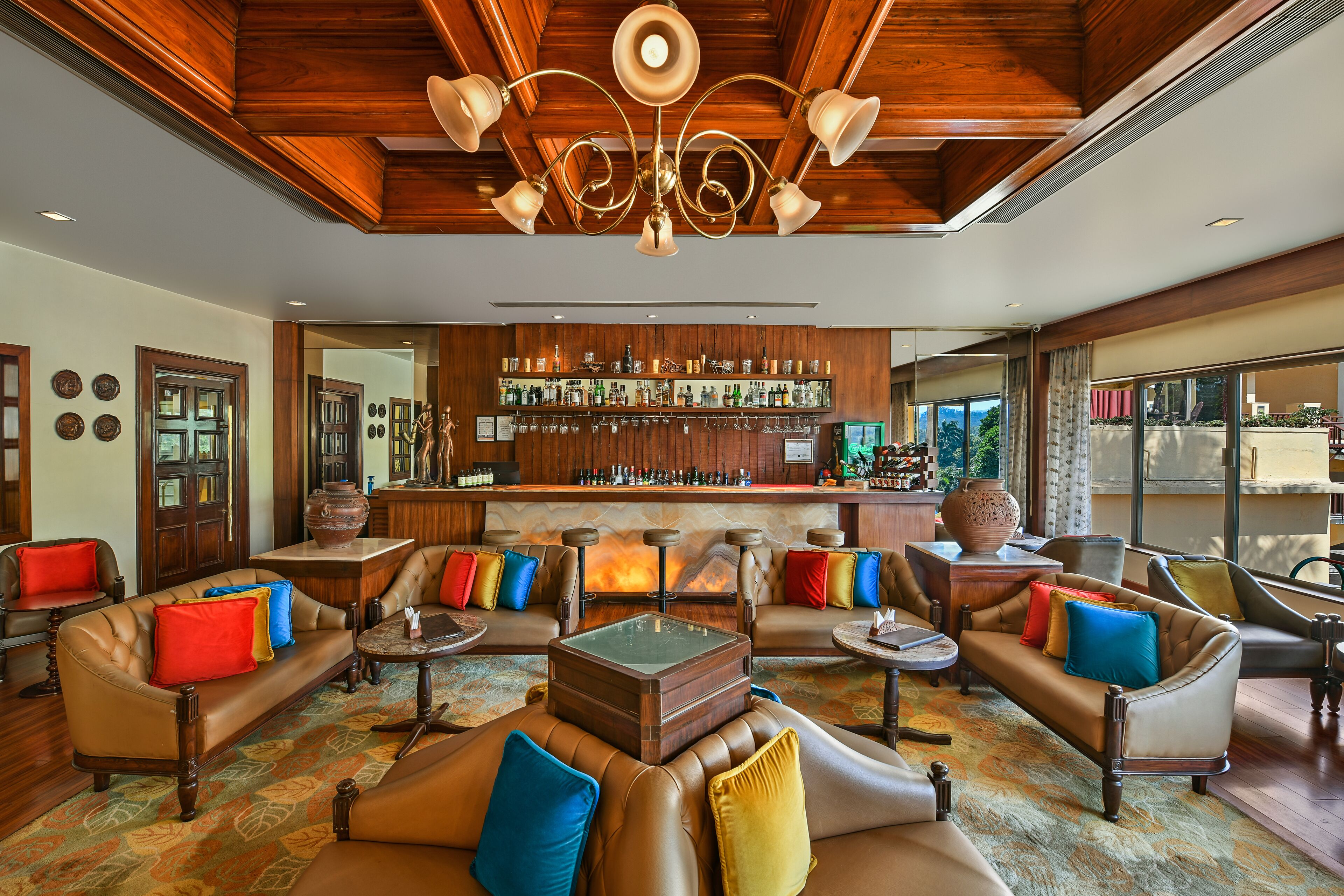 A spacious lobby with leather sofas, a bar area, and a fireplace.