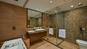 A modern bathroom with a glass-enclosed shower, a large mirror, and a vanity with a sink and towel rack.