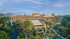 A large hotel with multiple balconies, a swimming pool, and a water slide. - Fariyas Resort Lonavala (Mawal)