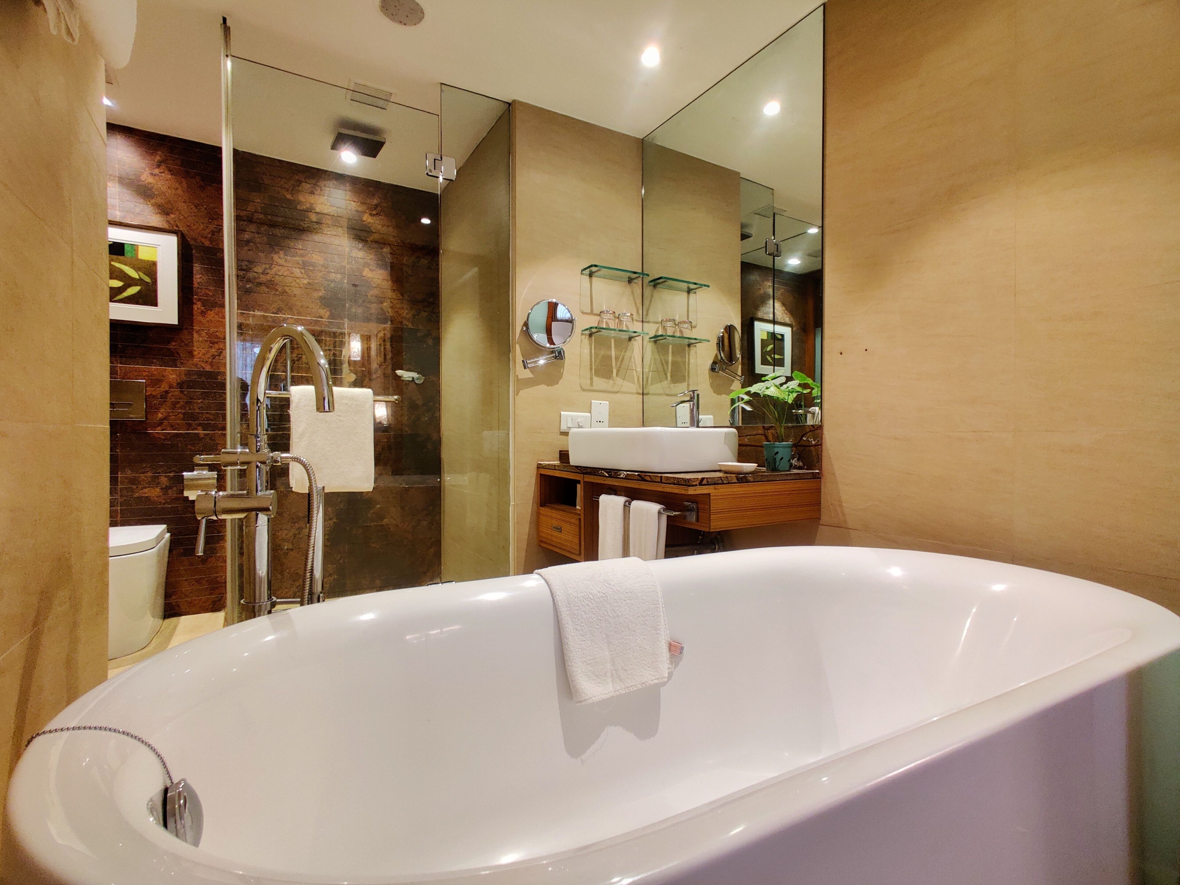 A modern bathroom with a freestanding bathtub, a glass shower enclosure, and a vanity with a mirror.