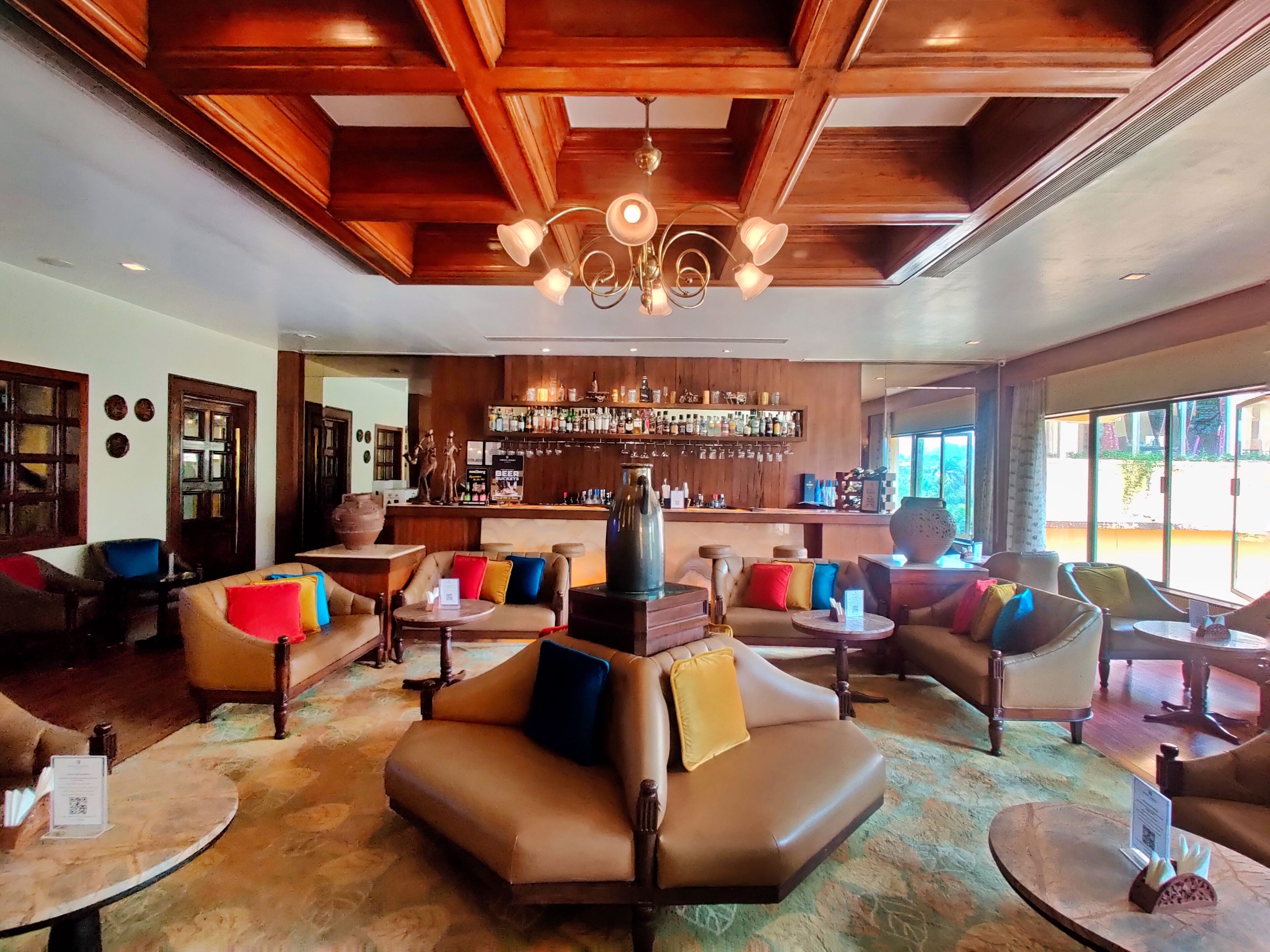 A spacious lobby with leather sofas, a bar area, and large windows.