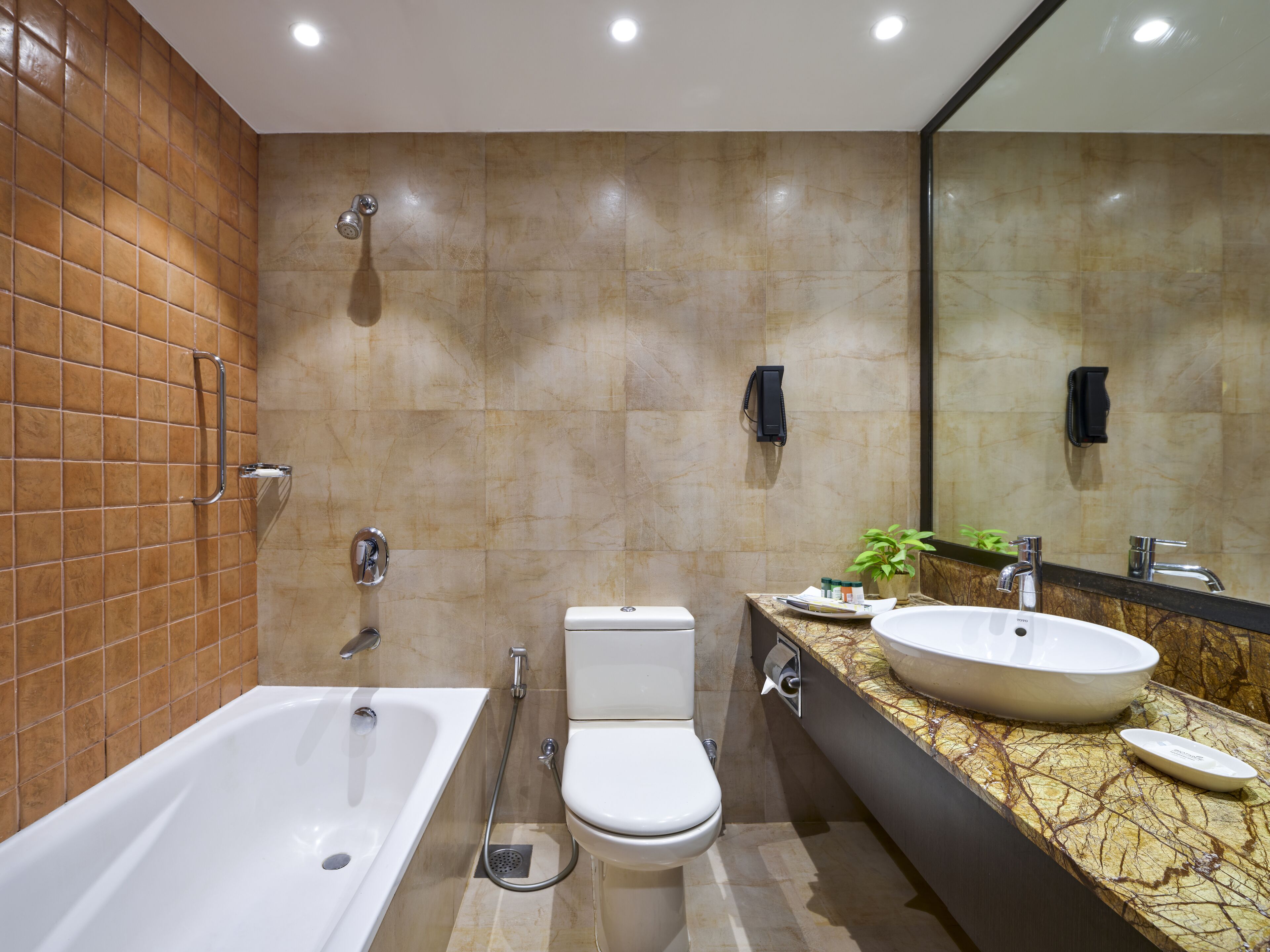 Ein modernes Badezimmer mit Badewanne, Toilette und Waschbecken.