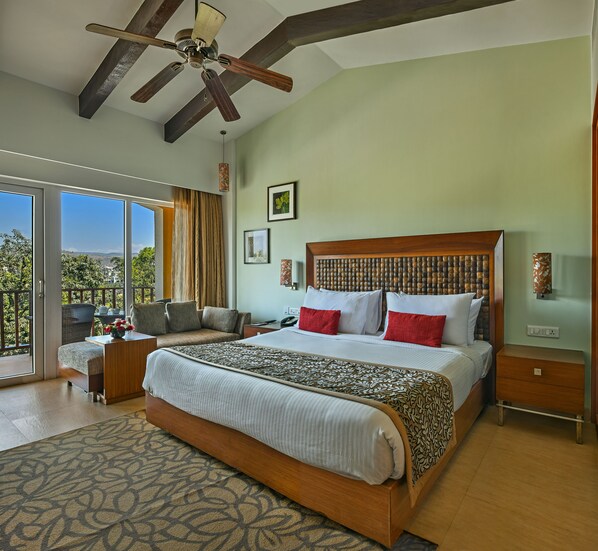 A spacious bedroom with a large bed, a ceiling fan, and a view of the outdoors.