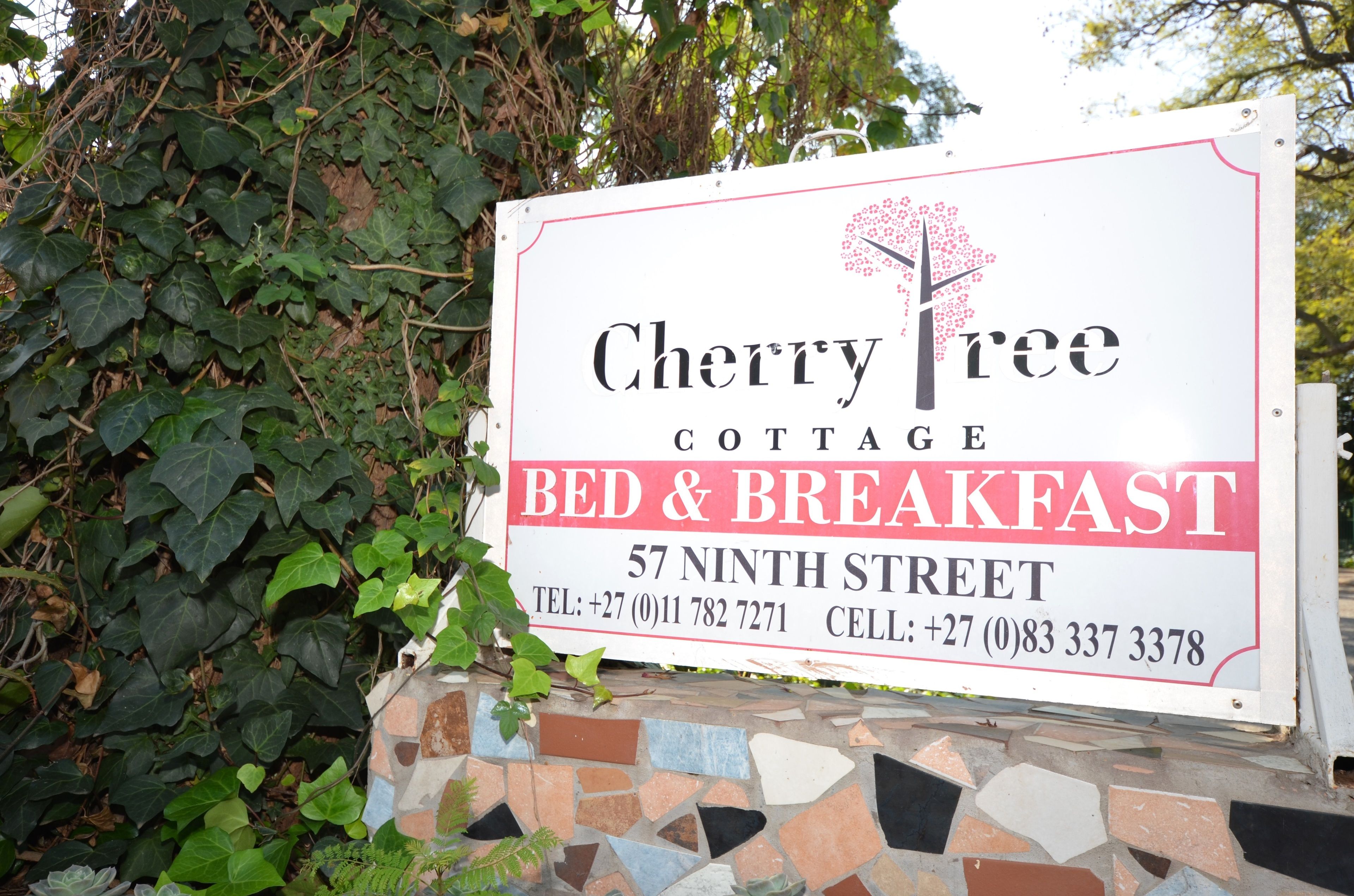 A sign for Cherry Tree Cottage Bed & Breakfast, including the name, services, and contact information.