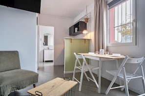 Um espaço compacto com área de refeições, cozinha compacta e sofá.