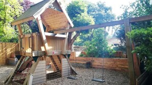 Un gallinero de madera con techo inclinado y entrada de malla de alambre.