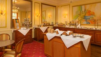 Uma sala de jantar formal com um aparador de madeira, um candelabro e um espelho grande.