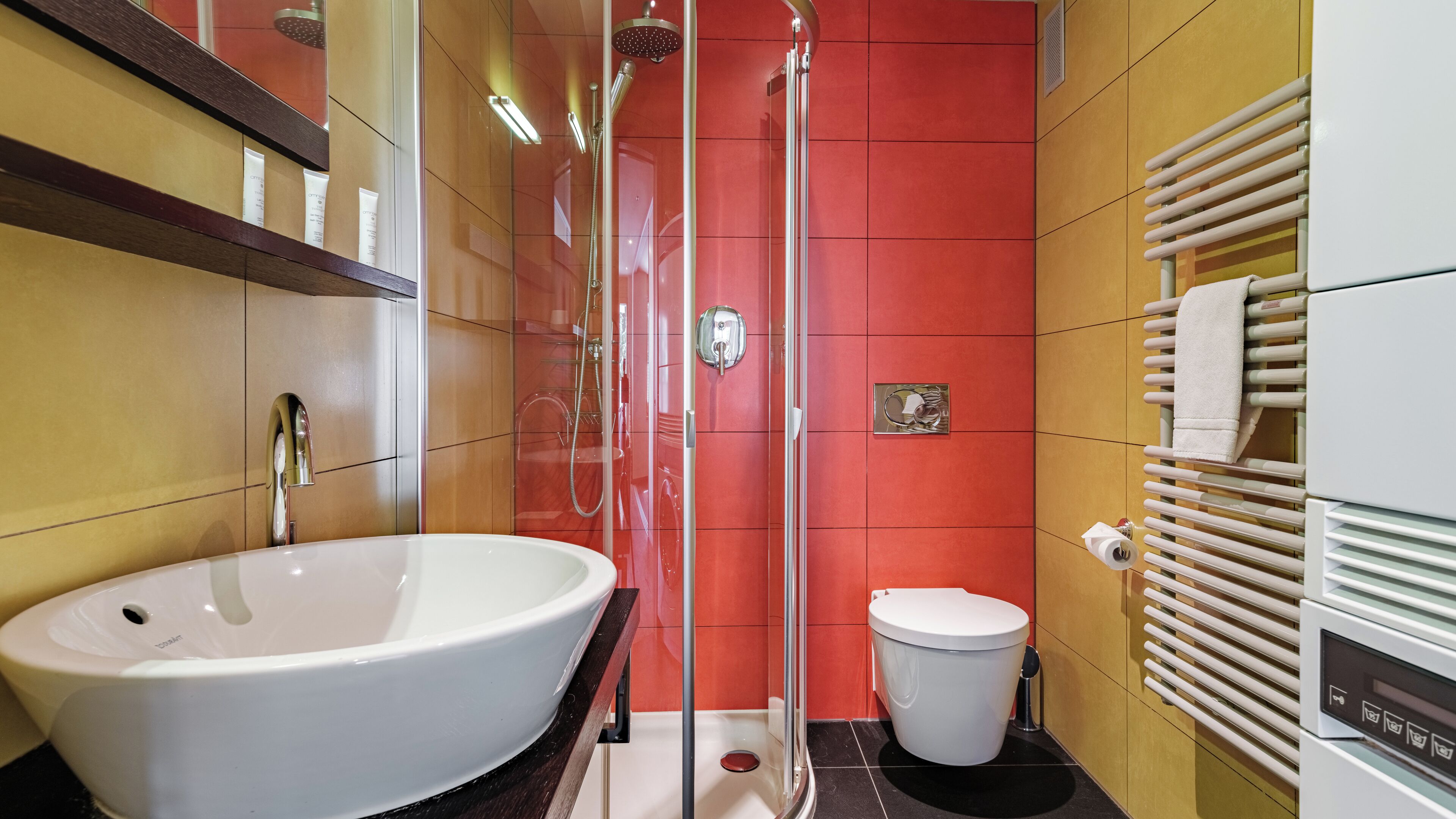 A bathroom with a large white sink, a glass-enclosed shower, and a white toilet.