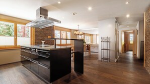 Una cucina moderna con isola centrale, pavimento in legno e vista sull'area pranzo.