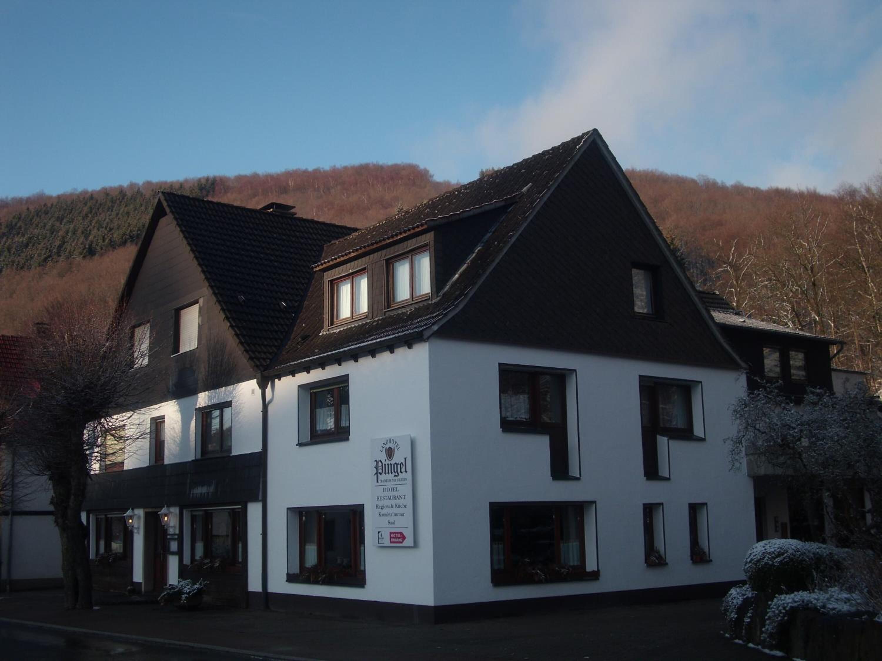 A two-story building with a sign indicating it is a hotel and restaurant.