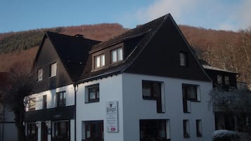A two-story building with a sign indicating it is a hotel and restaurant.