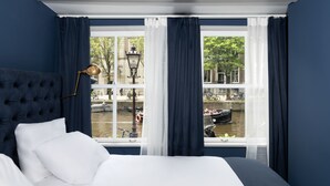 A bedroom with a large window, a bed, and a lamp. - Stanley Collection Hotel Hegra Amsterdam (Amsterdam)