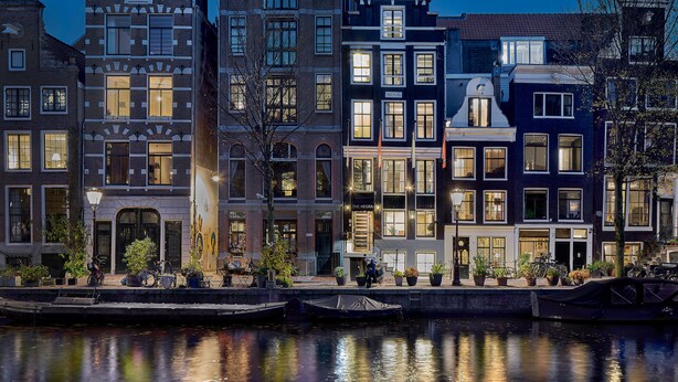 A row of historic buildings with large windows and a canal in the foreground. - Stanley Collection Hotel Hegra Amsterdam (Amsterdam)