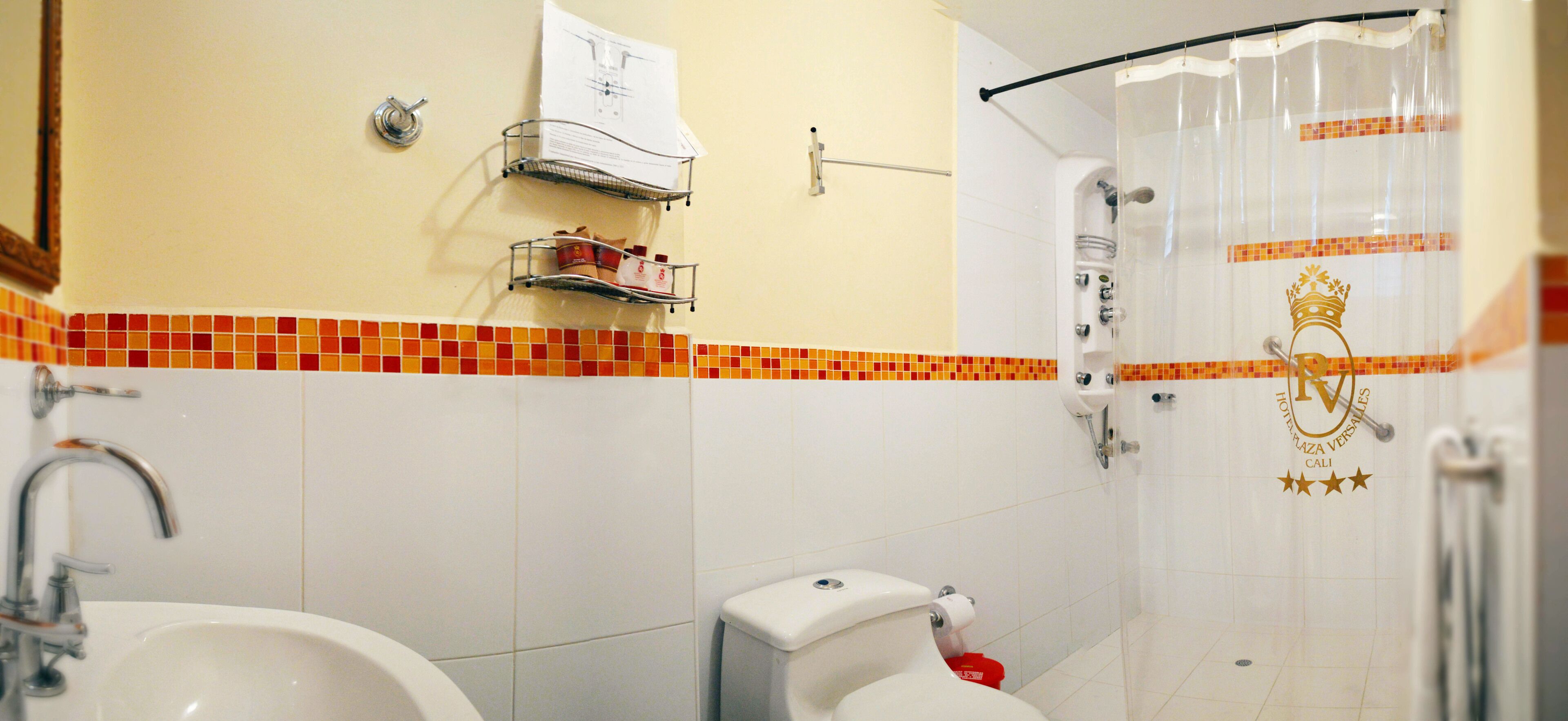 Een badkamer met toilet, wastafel en douchehoek.