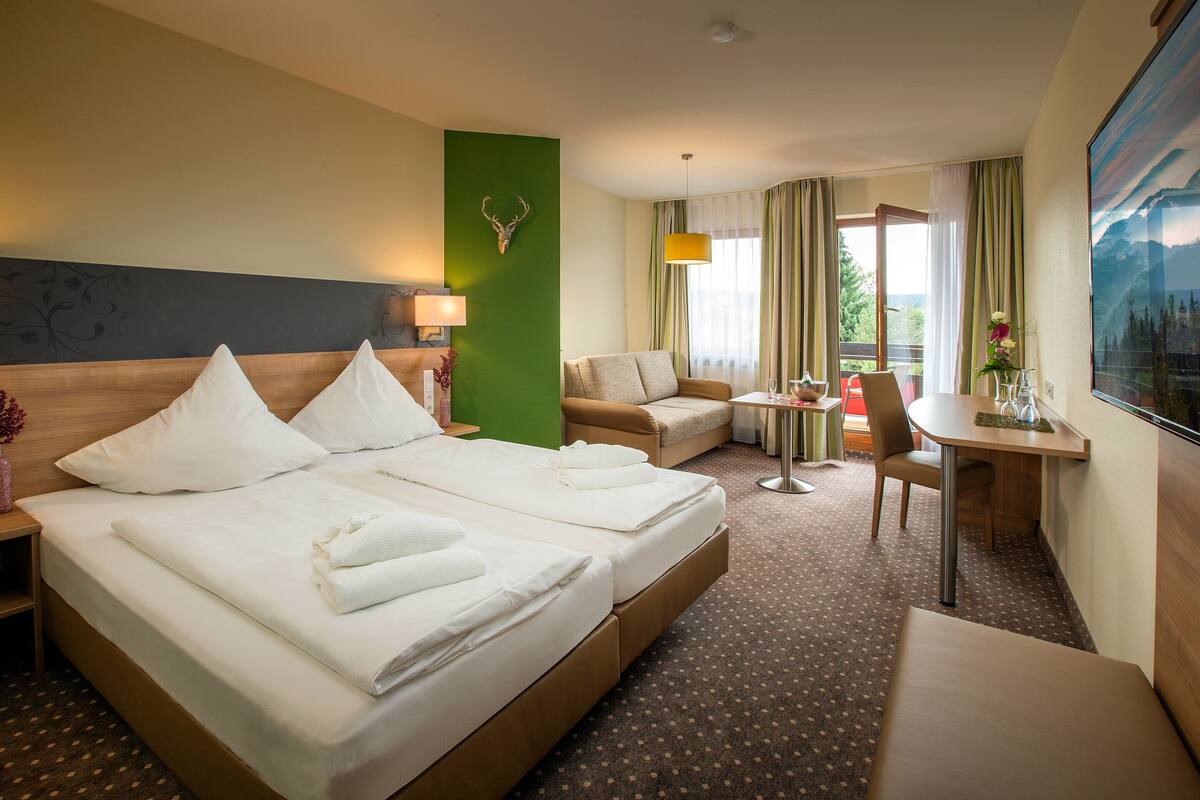 Une chambre d’hôtel avec un grand lit, un bureau, une chaise et un canapé.