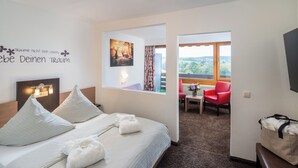Une chambre d’hôtel équipée d’un lit, d’un bureau, d’une chaise, d’une fenêtre avec vue et d’un mur orné d’une citation inspirante.