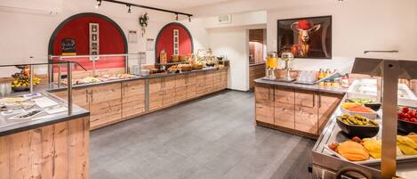 A buffet area with various food items and a wooden counter.