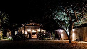 A house with a porch, a covered entryway, and a large tree in the foreground. - Elephant Hide of Knysna Guest Lodge (Knysna)