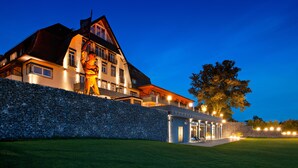 A large, multi-story building with a stone wall in front, a balcony, and a sign that reads "SB-Lounge". - Bodensee Hotel Sonnenhof (Kressbronn)