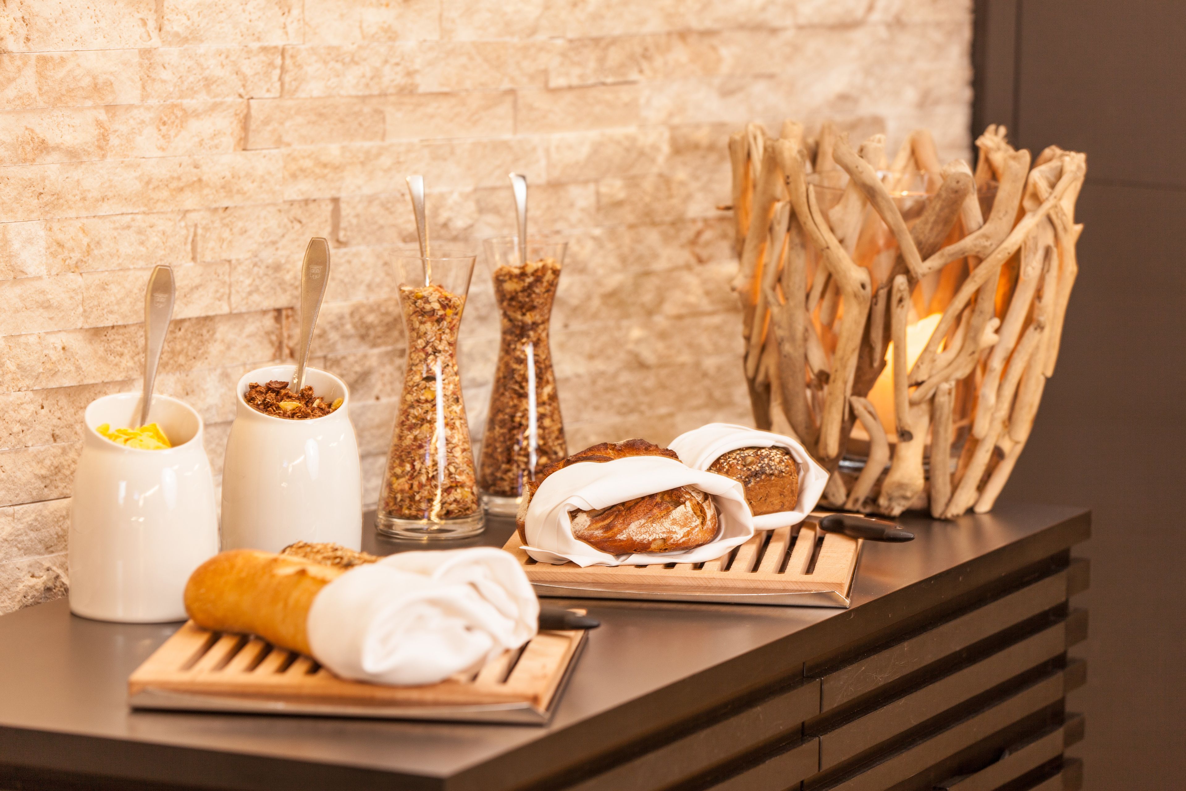 A breakfast buffet with bread, pastries, and condiments.