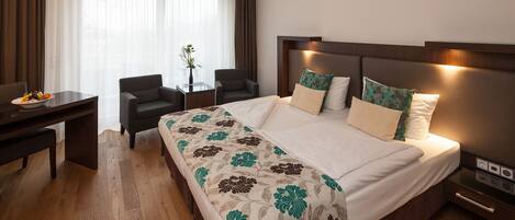 Una habitación de hotel con una cama grande, un escritorio y una silla.