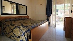 A bedroom with a bed, a large mirror, and a view of the outside. - Albergo Paradiso (Monte Compatri)