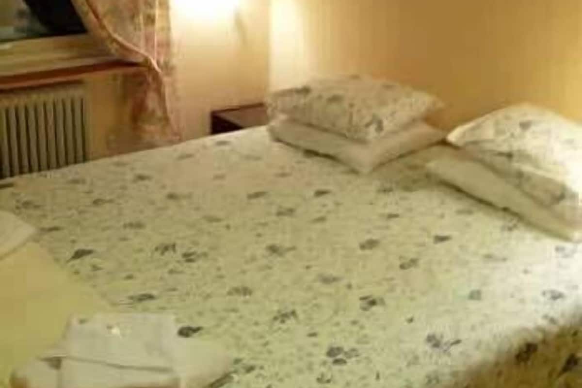 Ein Hotelzimmer mit einem Bett, einem Nachttisch und einer Wandlampe.