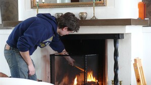 Une personne qui ajuste un paravent de cheminée.