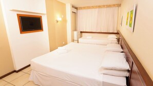 A hotel room with a large bed, a flat-screen TV, a bedside table, and a window with curtains. - Rede Andrade Hotel Canadá (Rio de Janeiro)