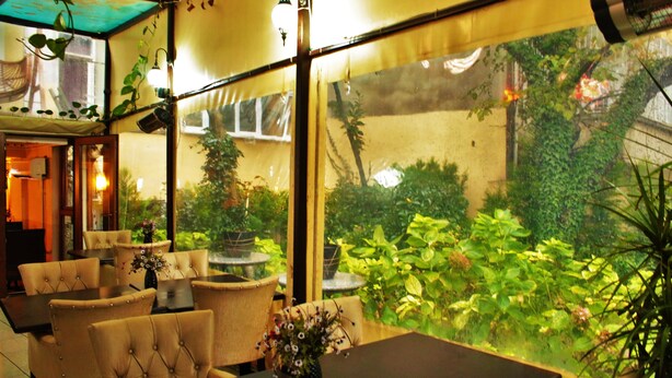 An indoor dining area with tables and chairs, large windows with a view of greenery outside. - Sultanahmet Park Hotel (Istanbul)