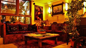 A cozy living room with a sofa, a coffee table, and a large painting of the Mona Lisa. - Sultanahmet Park Hotel (Istanbul)