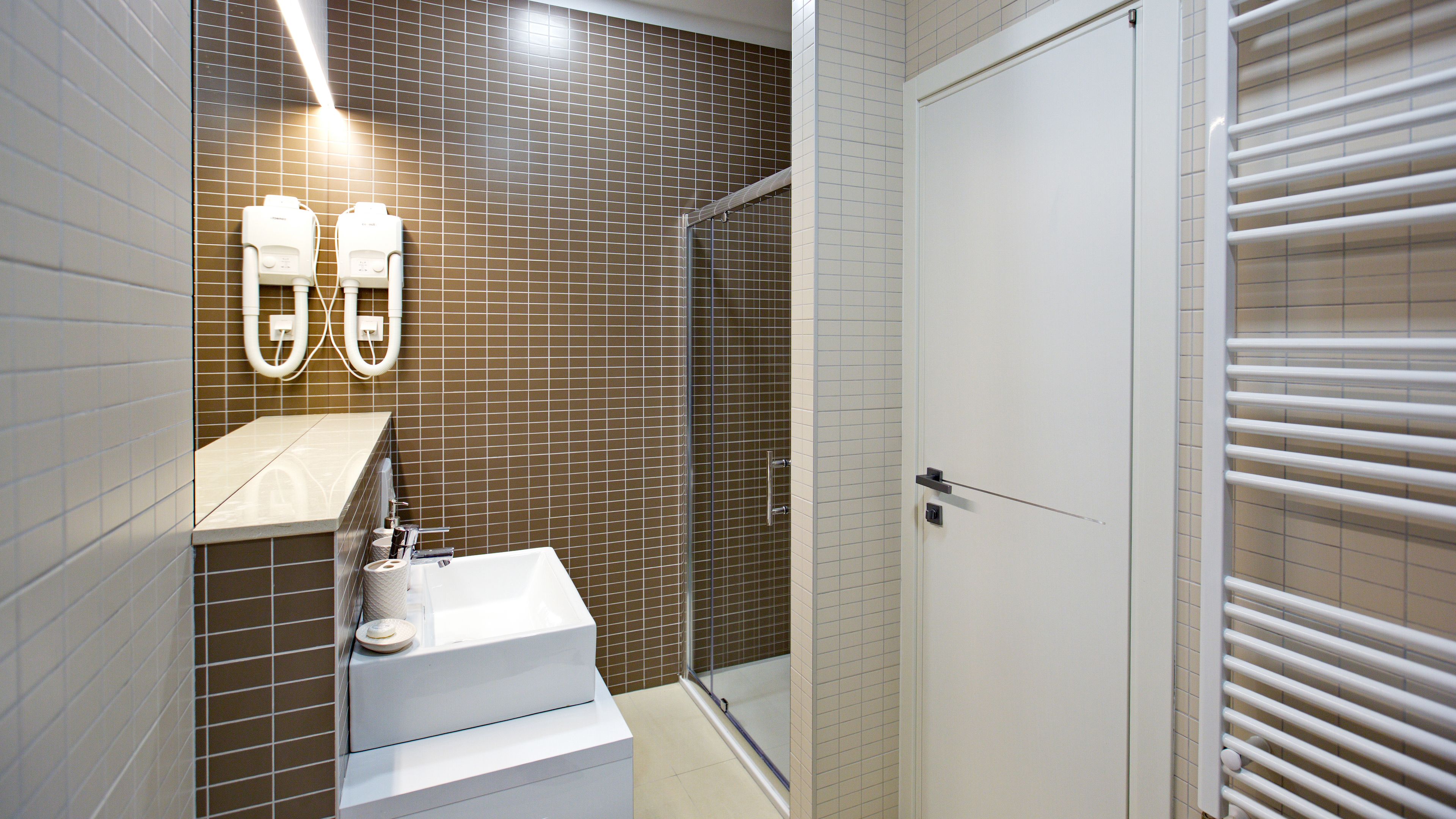 A modern bathroom with a shower, a toilet, and a sink.