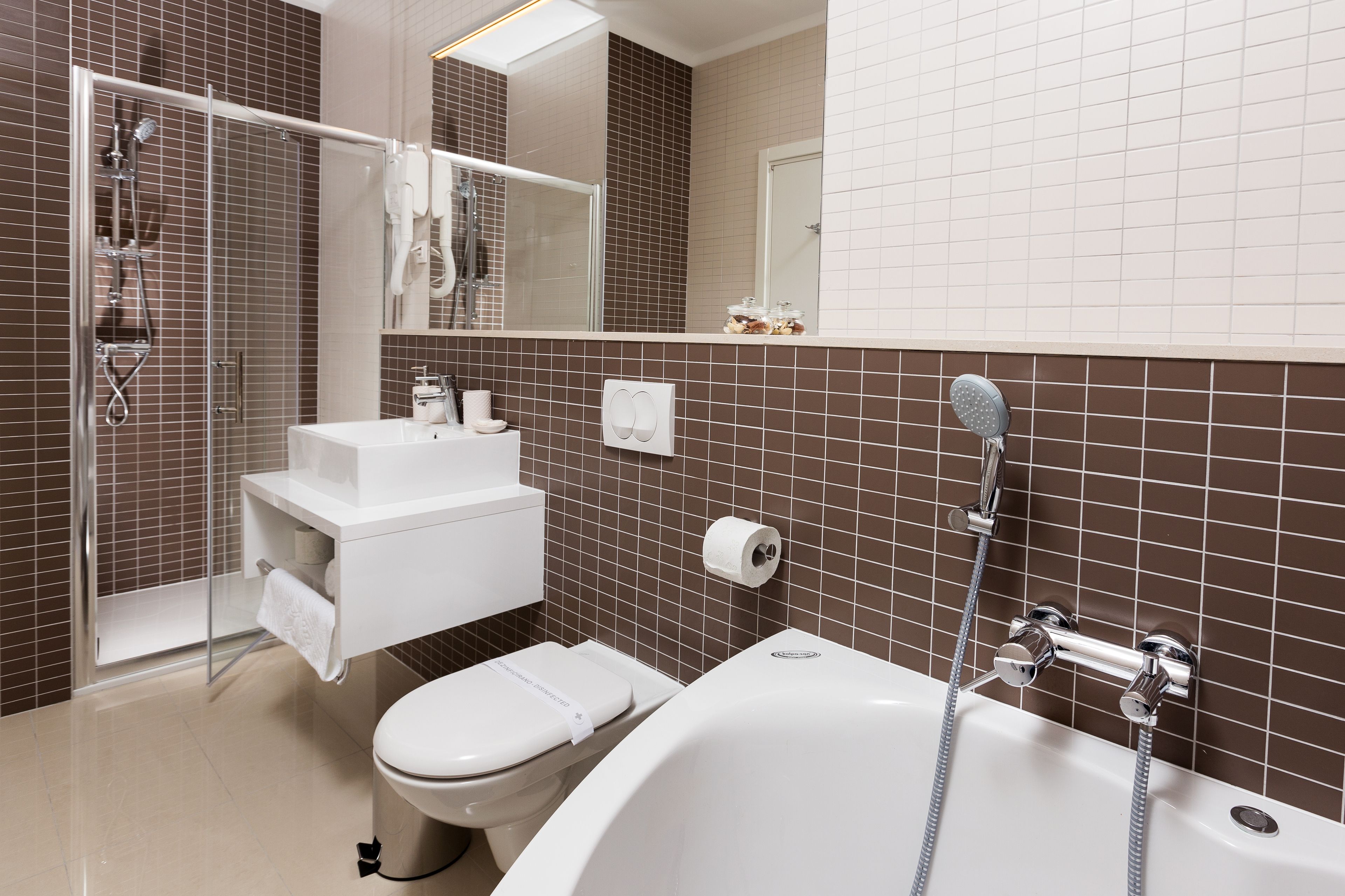 A modern bathroom with a shower, toilet, sink, and bathtub.