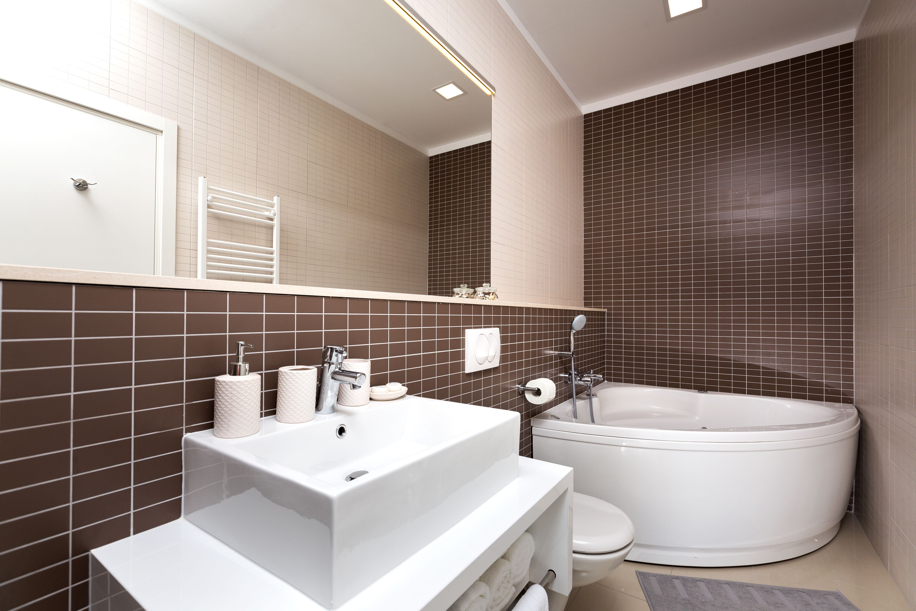 A modern bathroom with a white sink, toilet, and bathtub.