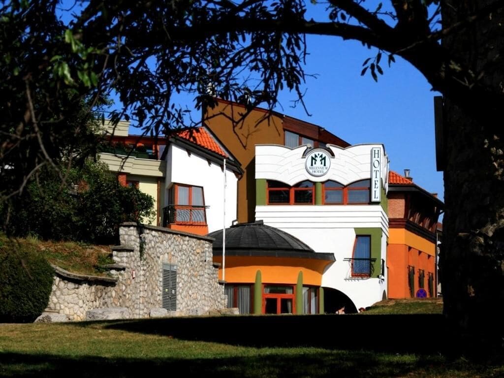 Un hotel con un estilo arquitectónico distintivo, que presenta un letrero llamativo con un logotipo y el nombre 'Hotel'.