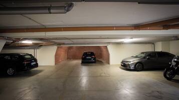En parkeringskælder med tre biler parkeret rækkebil.