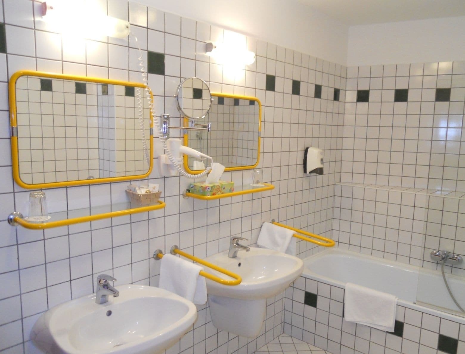 Un bagno con due lavandini, una vasca e uno specchio.