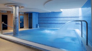 A modern indoor swimming pool with a clear water feature, wooden panel walls, and a tiled floor. - Sándor Hotel (Pecs)