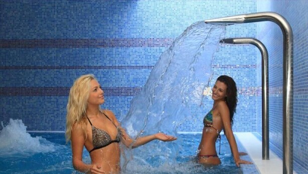 Two people in a swimming pool with a water feature. - Sándor Hotel (Pecs)