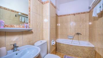 Une salle de bain avec un lavabo, des toilettes et une baignoire.