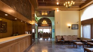 A lobby with a reception desk, seating area, and a chandelier. - Sunset Hotel Corfu (Corfu)