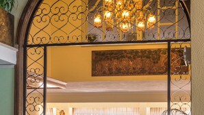 A lobby with a chandelier, seating area, and a decorative metal gate. - Sunset Hotel Corfu (Corfu)