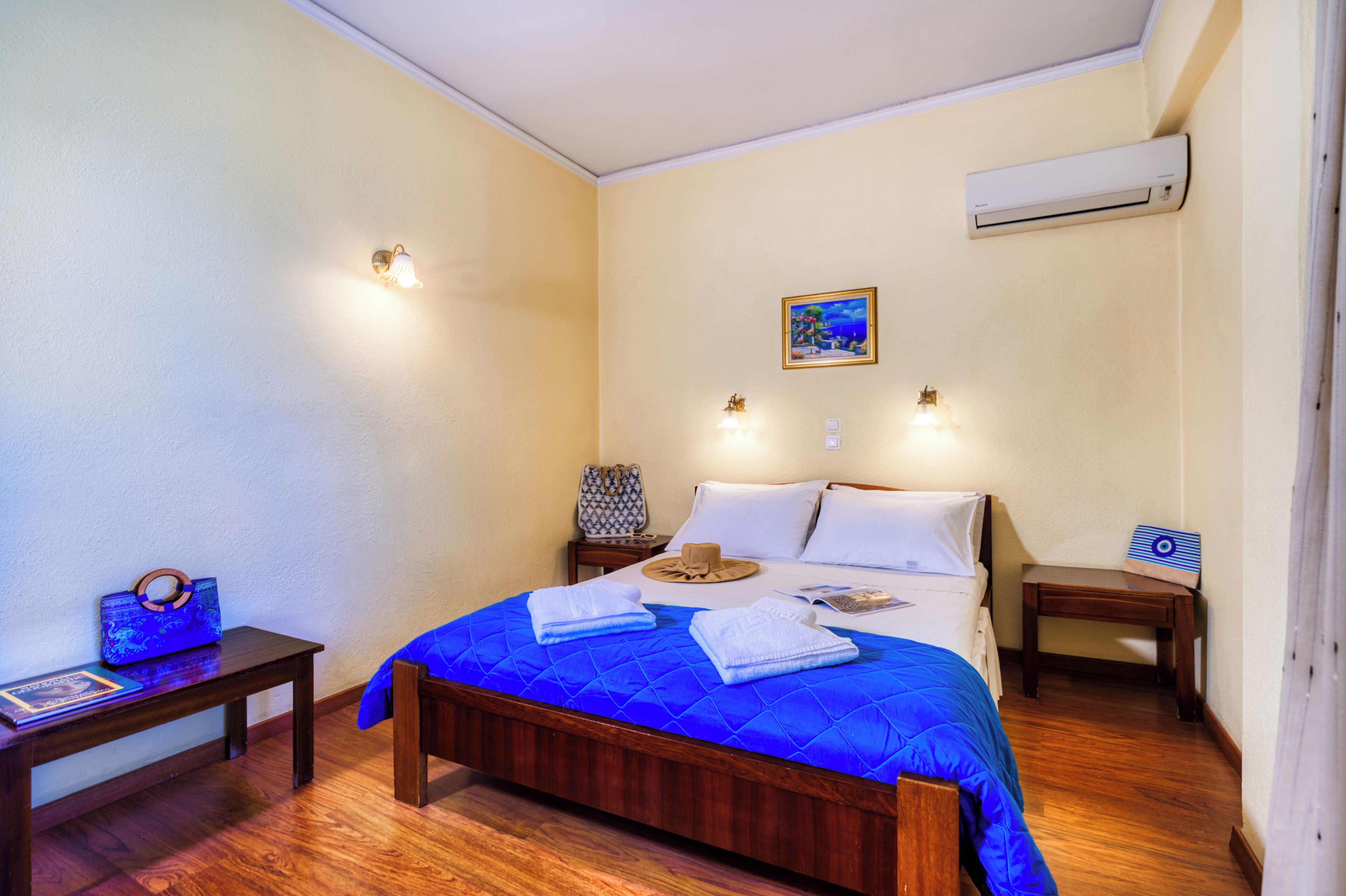 Un dormitorio con una cama de madera, una mesita de noche y un cuadro en la pared.