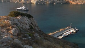 A rocky coastline with a dock and boats.